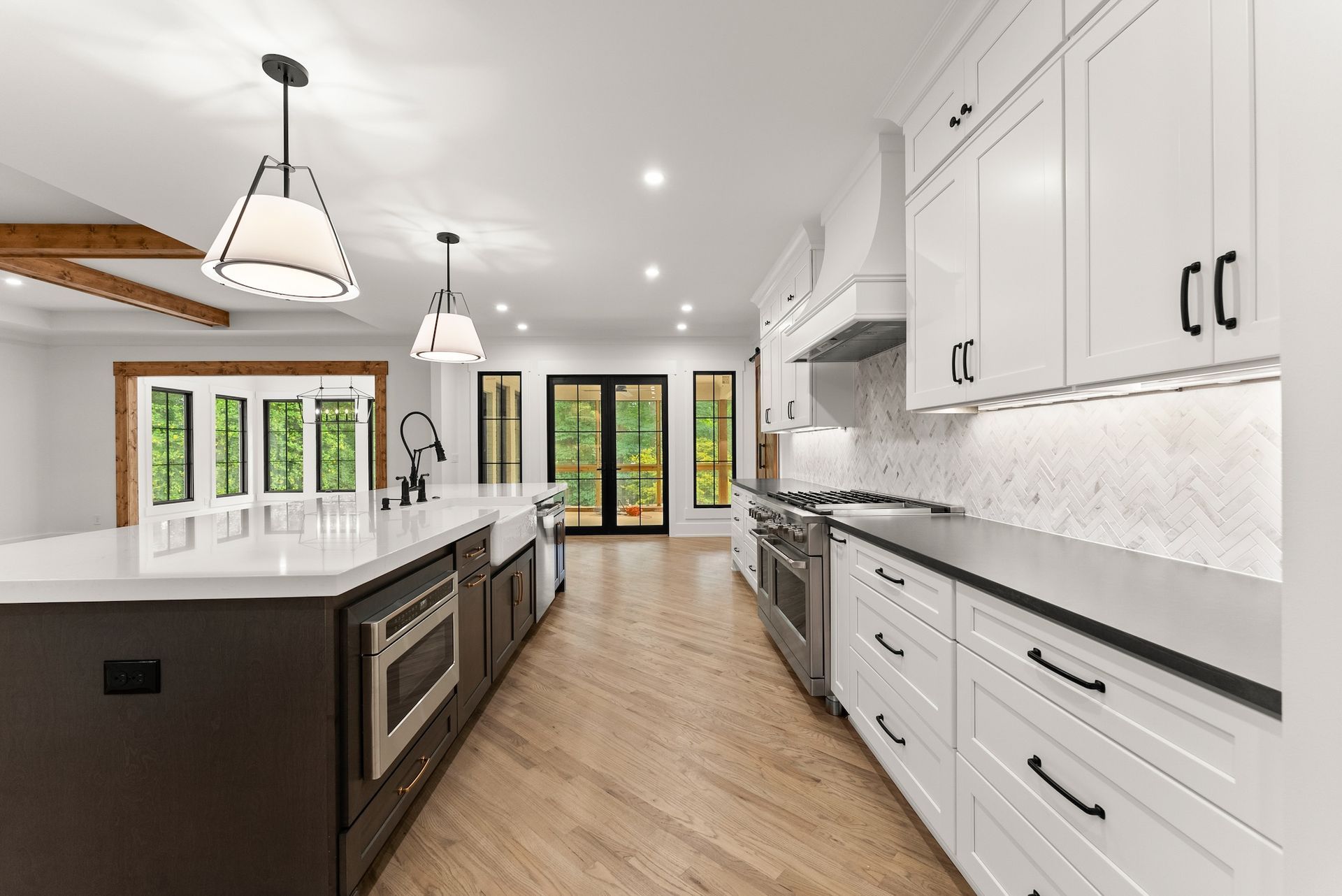 A kitchen with white cabinets , black counter tops , and stainless steel appliances.