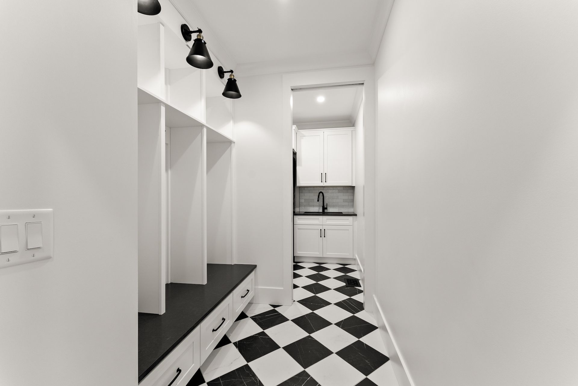 A black and white photo of a hallway with a checkered floor.