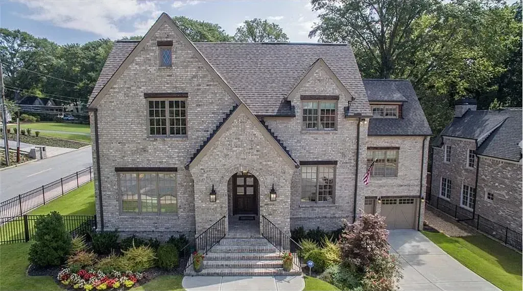 An aerial view of a large brick house surrounded by trees.