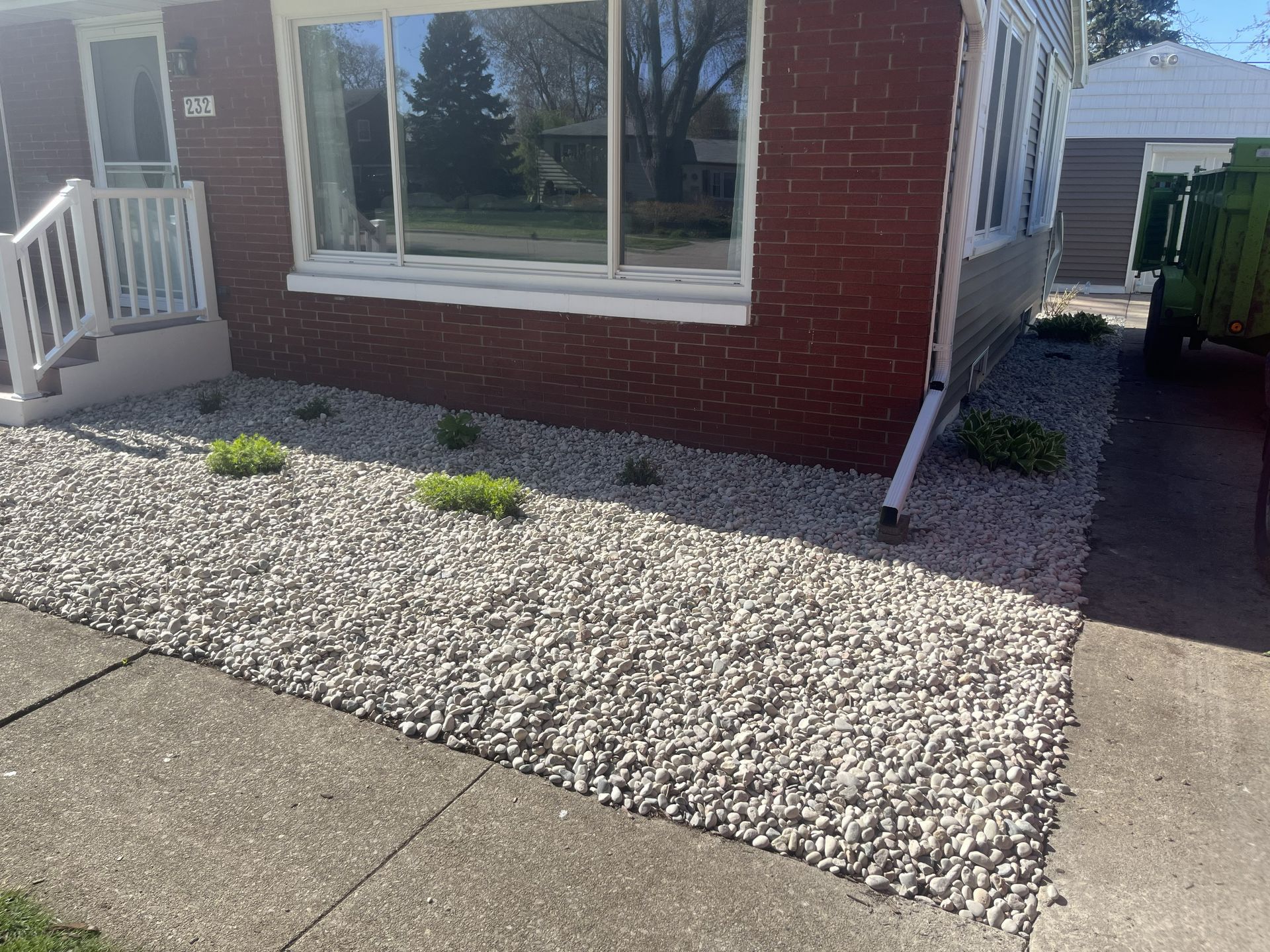 House exterior with rock landscaping and small plants.