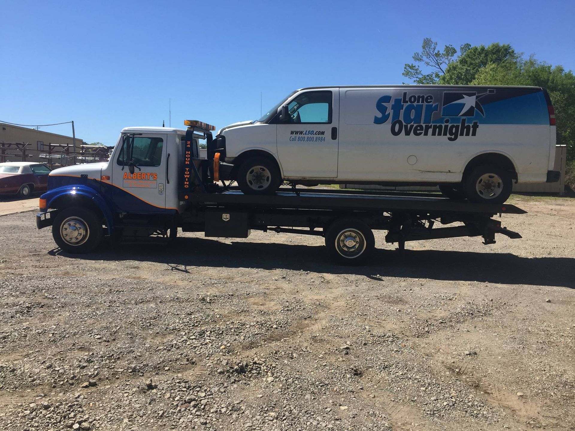 Tow truck carrying a white van labeled 