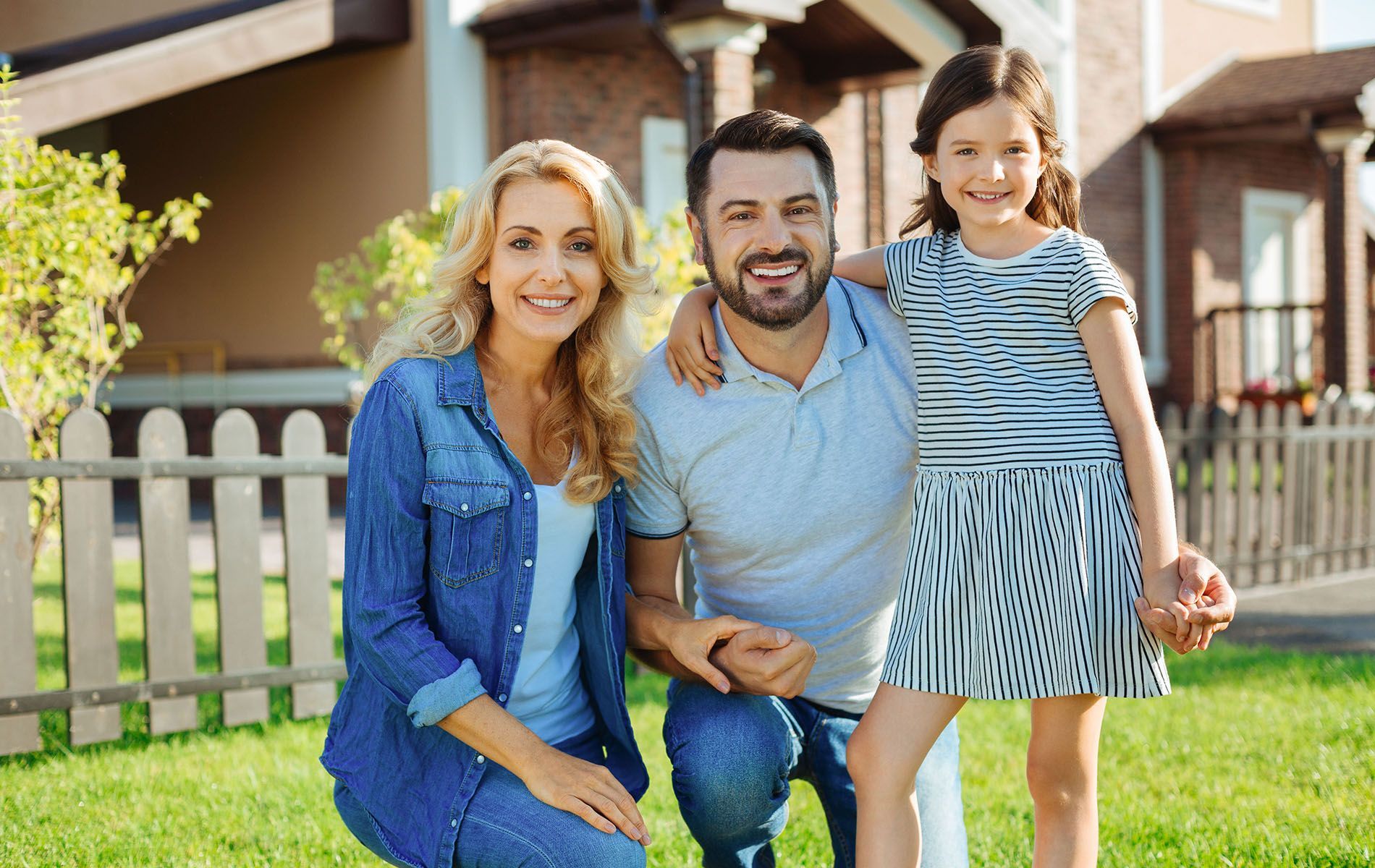 A family is posing for a picture in front of their house.