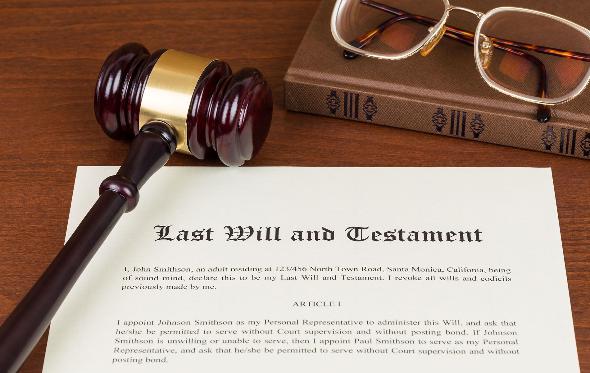 A wooden gavel sitting on top of a last will and testament