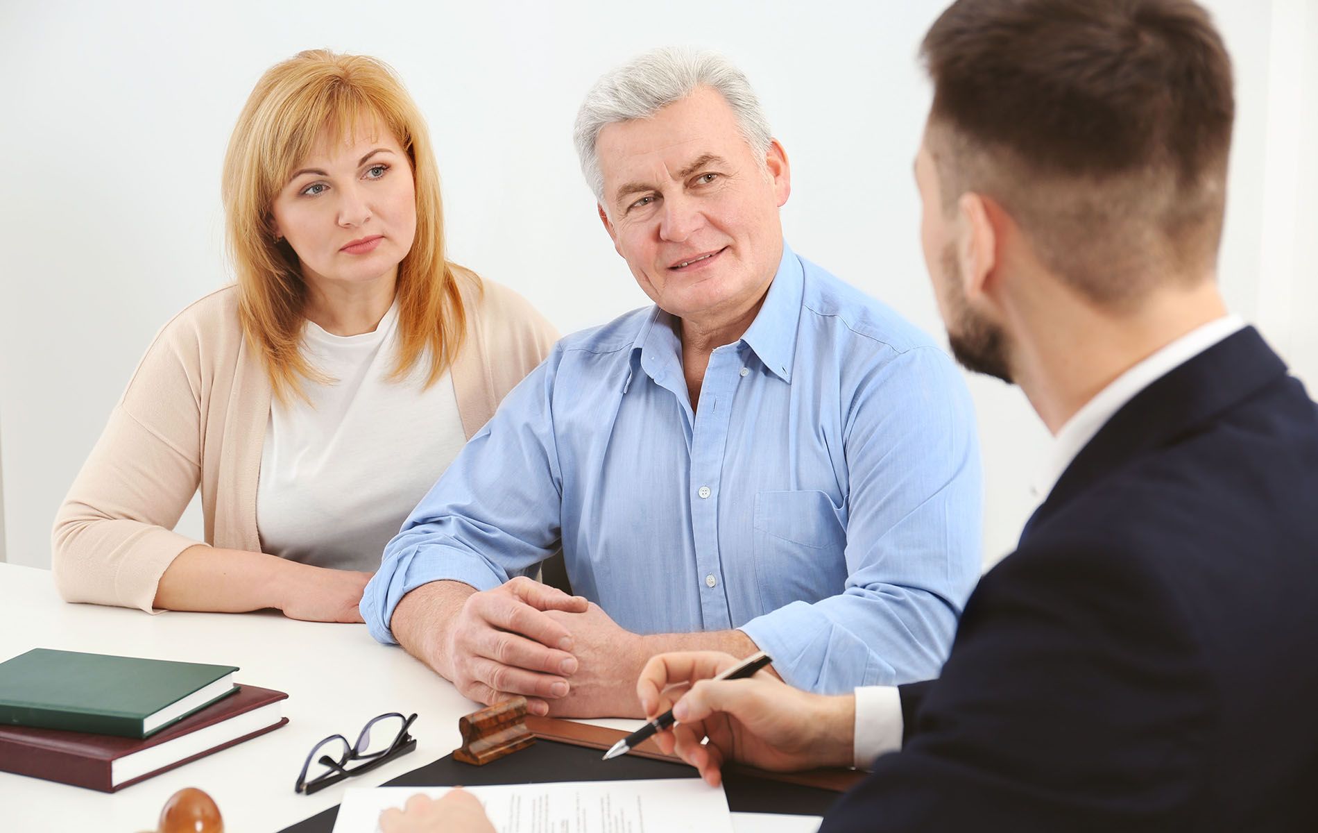 A man and a woman are sitting at a table talking to a lawyer.