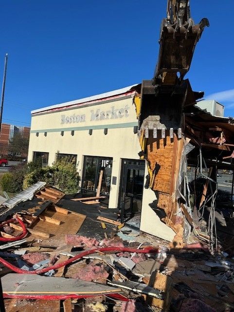 A Boston Market building is being demolished by a bulldozer.