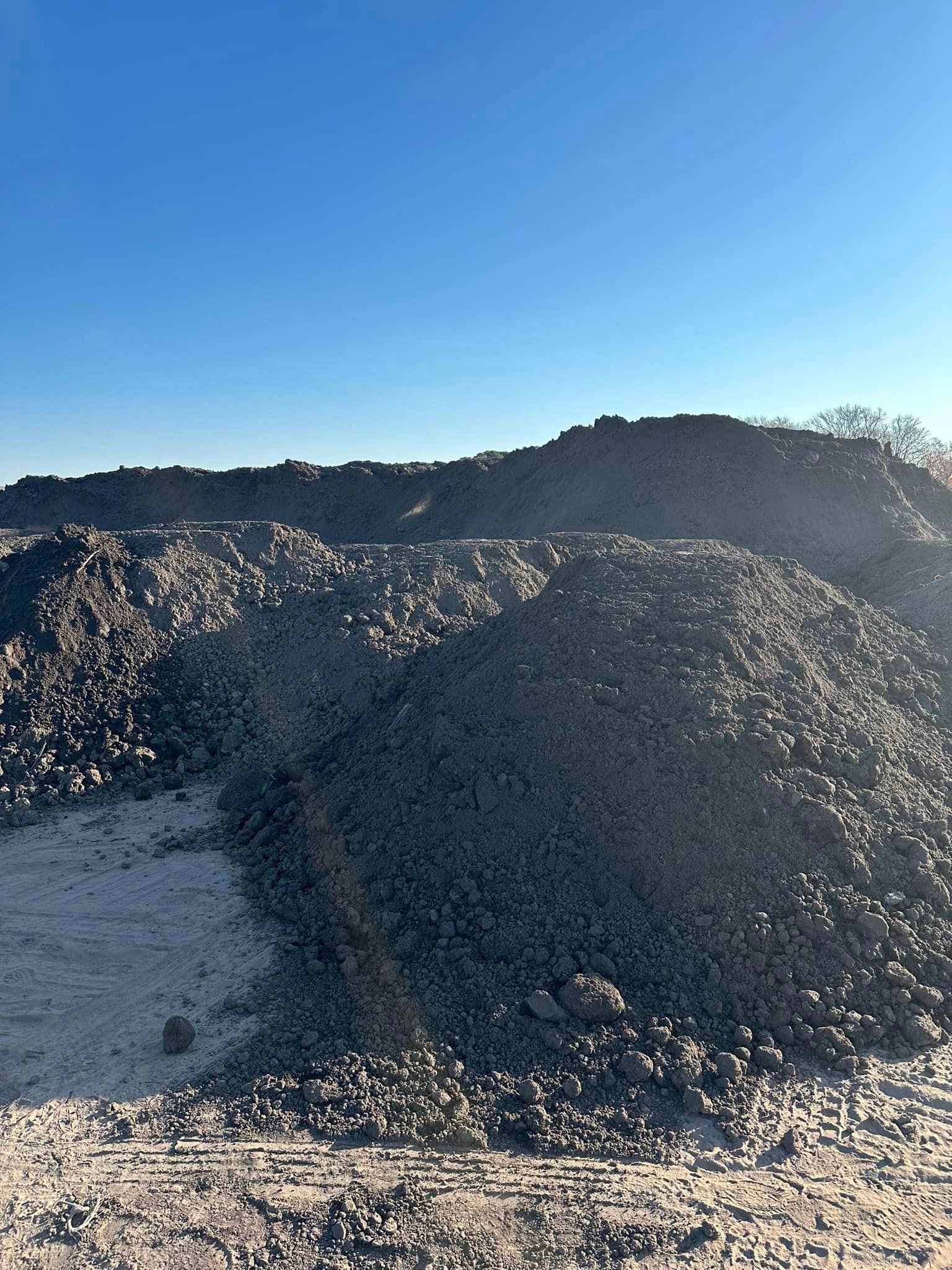 A large pile of dirt is sitting on top of a dirt field.