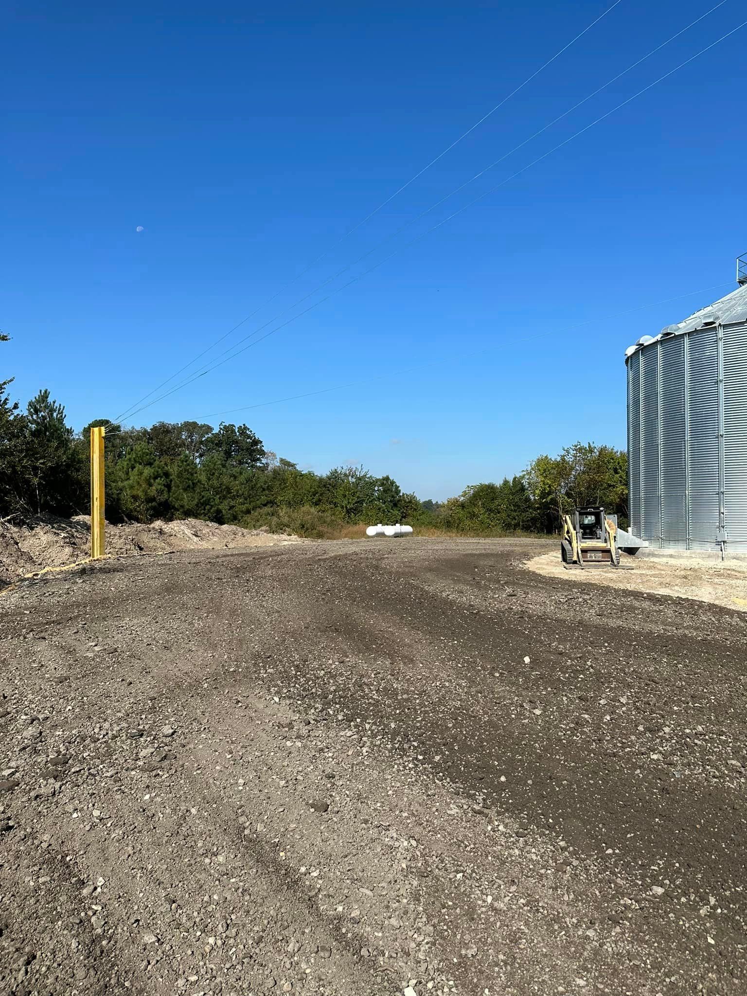 A gravel road leading to a building with a blue sky in the background.