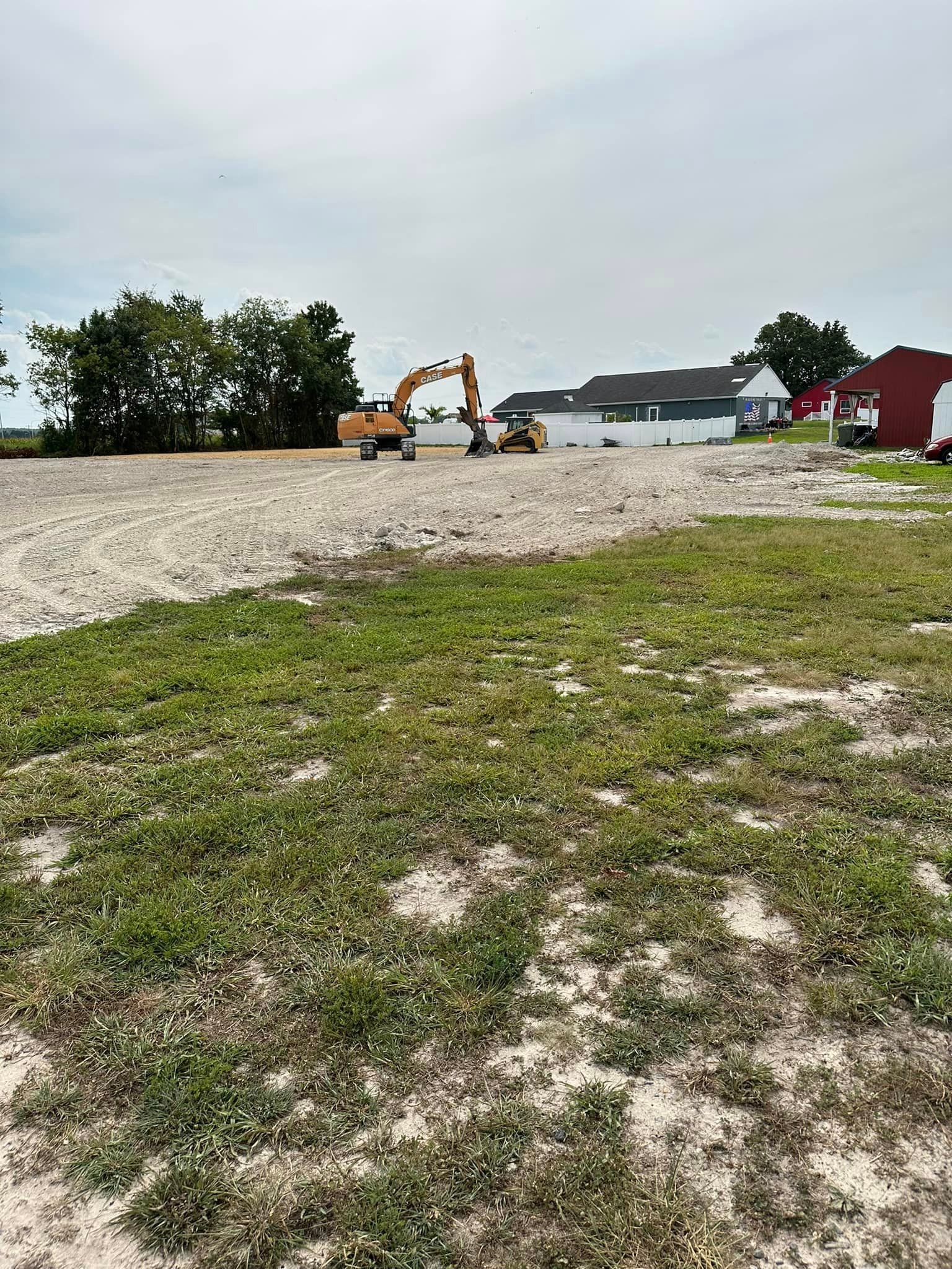 A large grassy field with a red barn in the background.