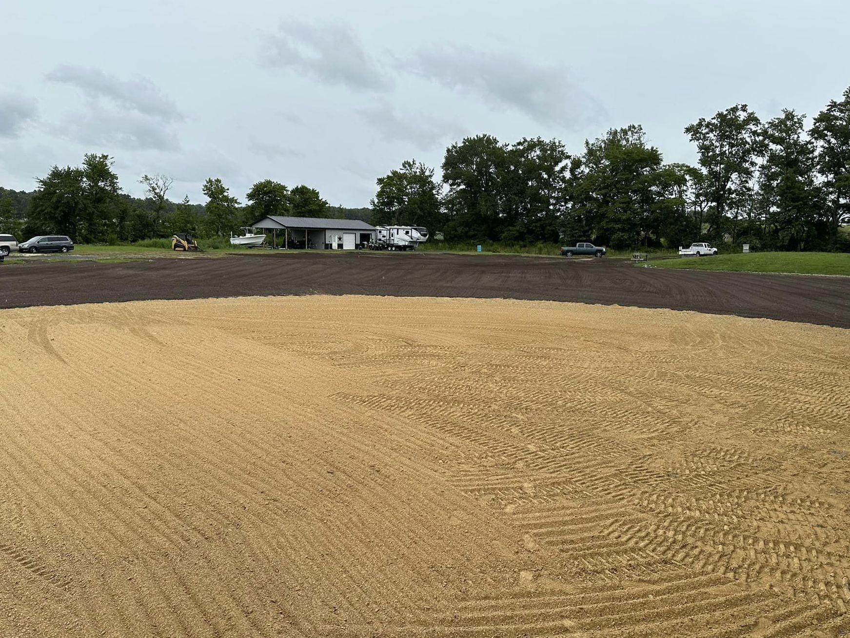 A dirt field with a house in the background