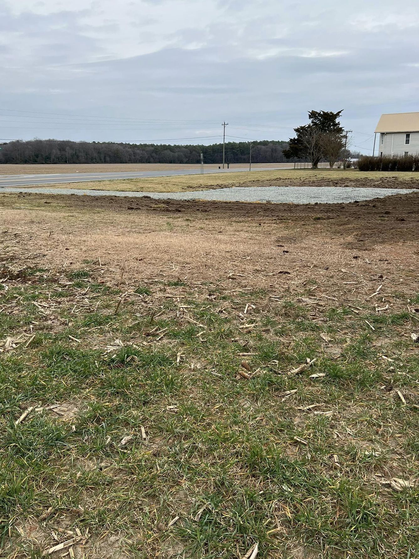 A large grassy field with a house in the background.