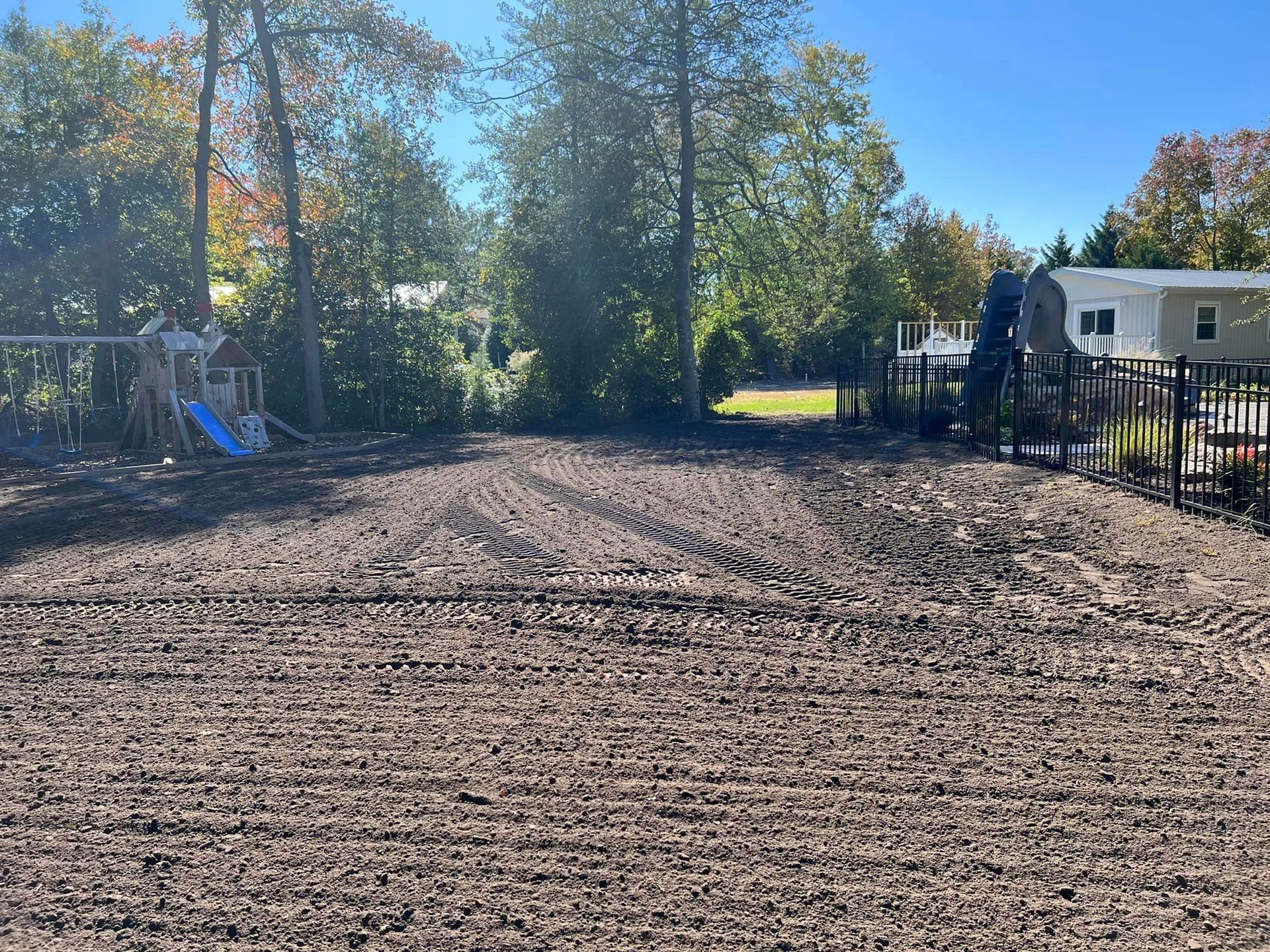 A dirt field with a playground in the background.