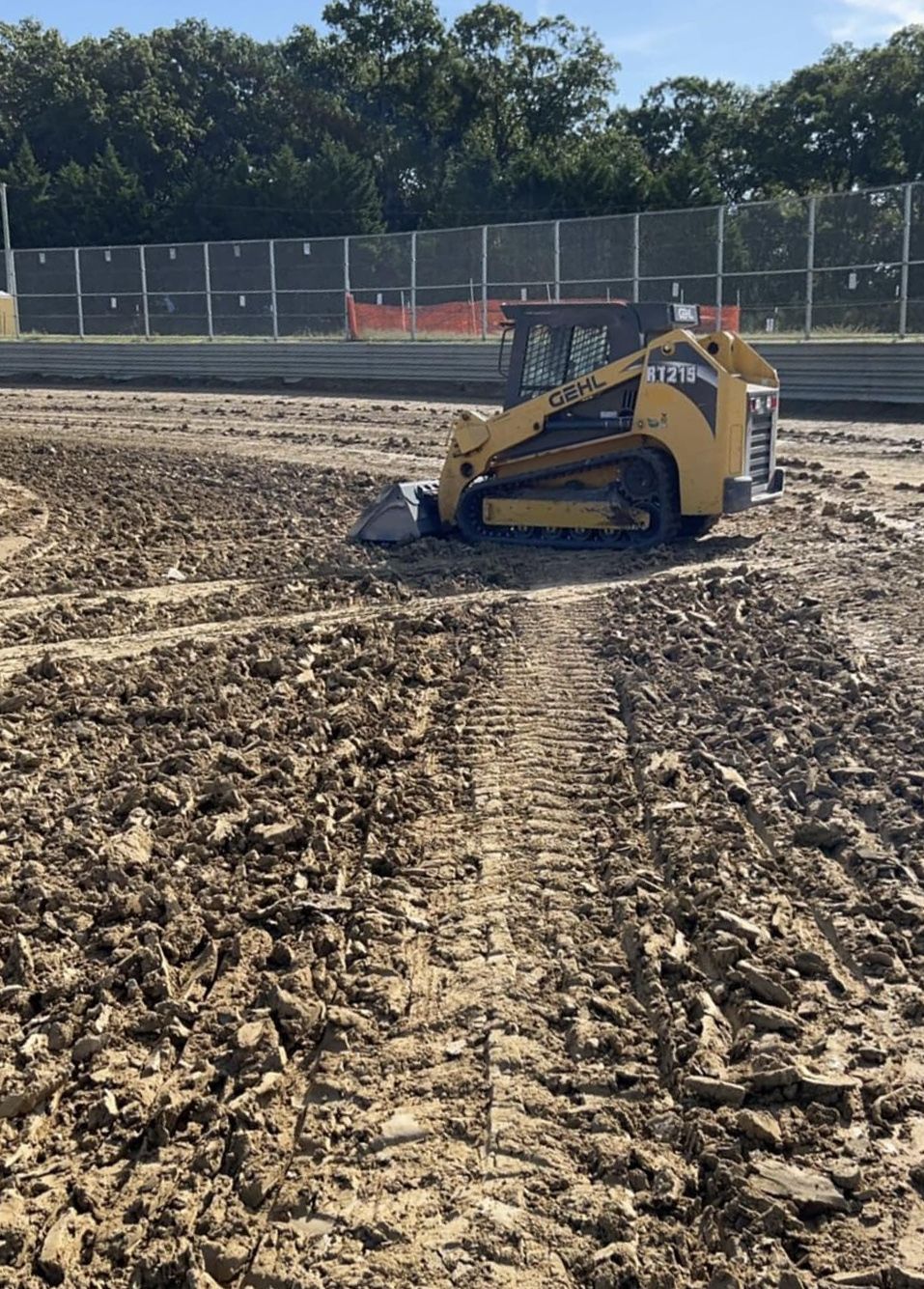 A bulldozer is driving through a muddy field.