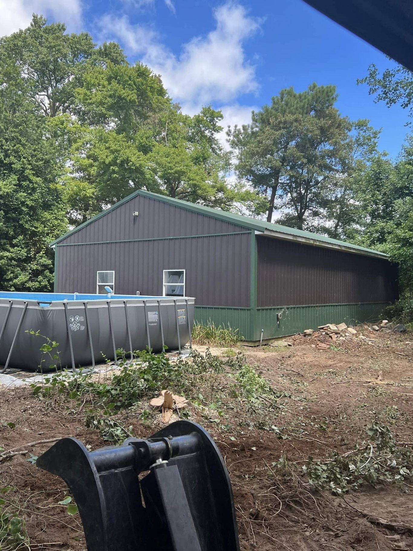 A large metal building with a pool in front of it.