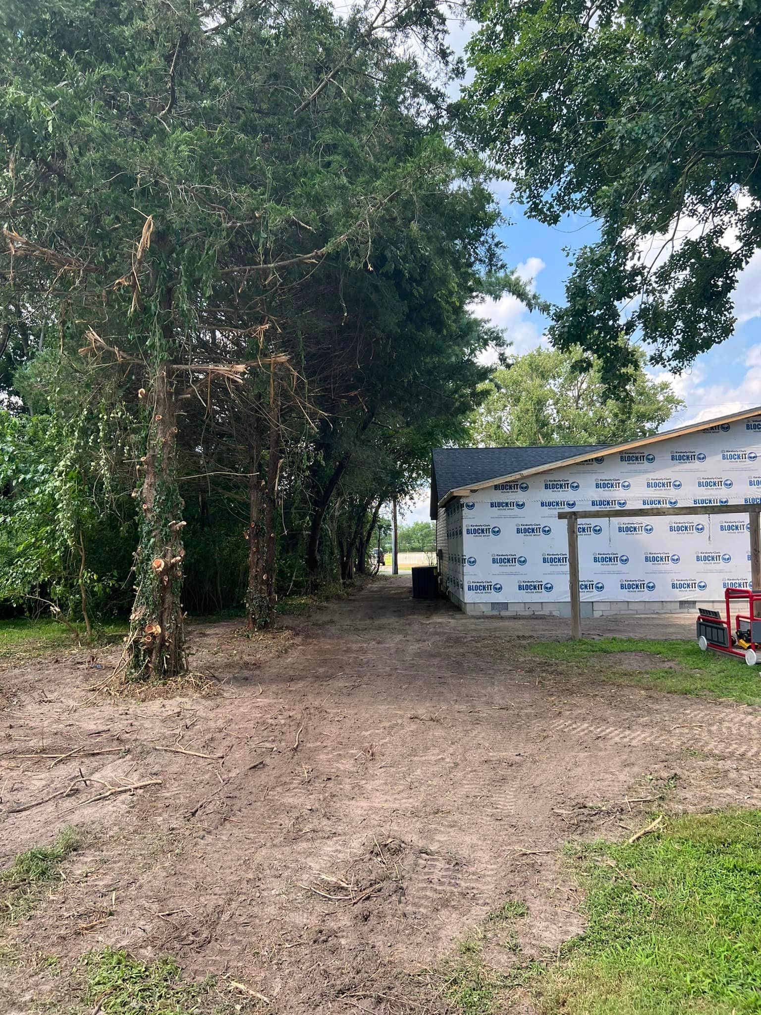 A dirt road leading to a garage with trees in the background.