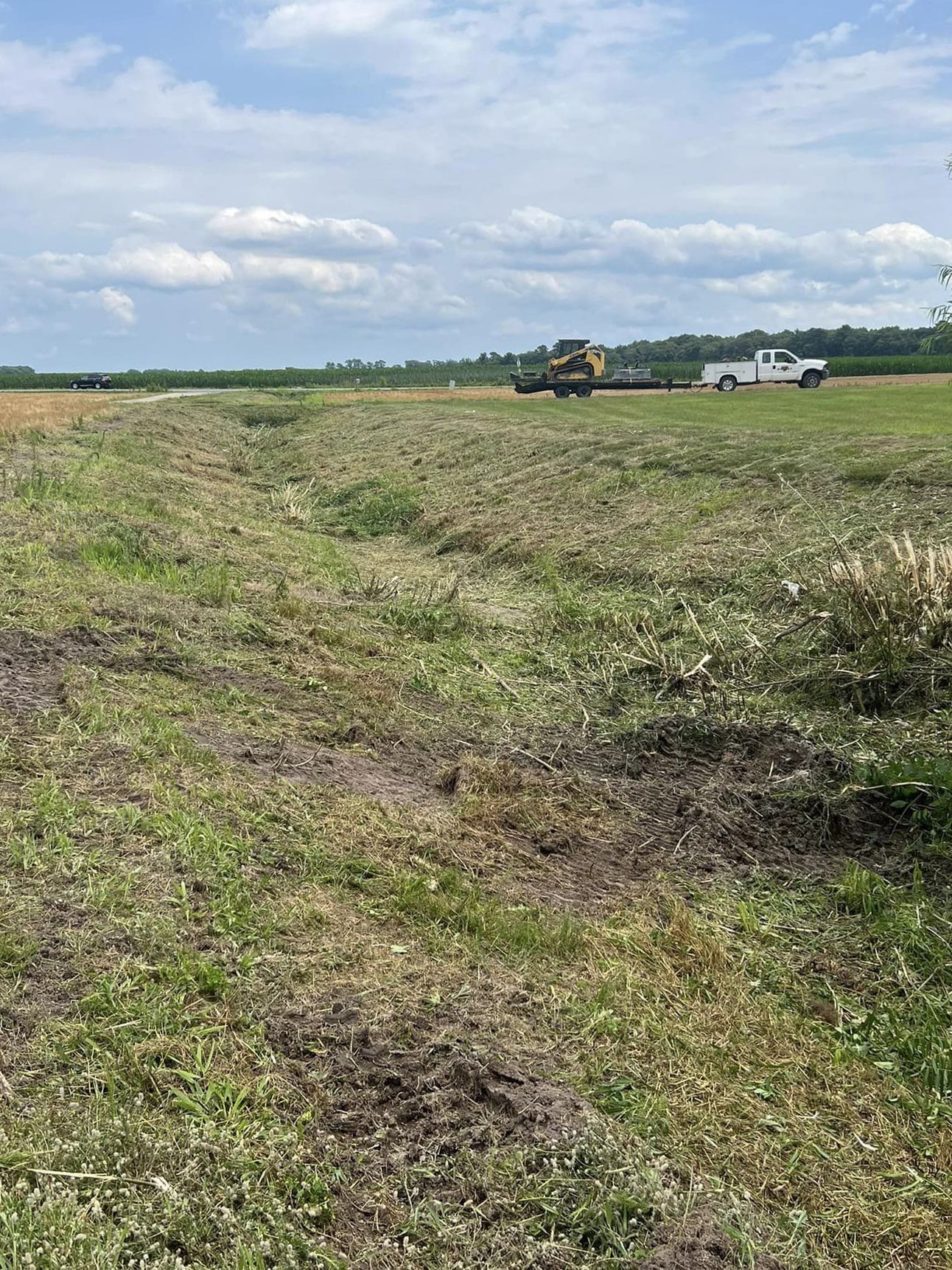 A truck is parked in the middle of a grassy field.