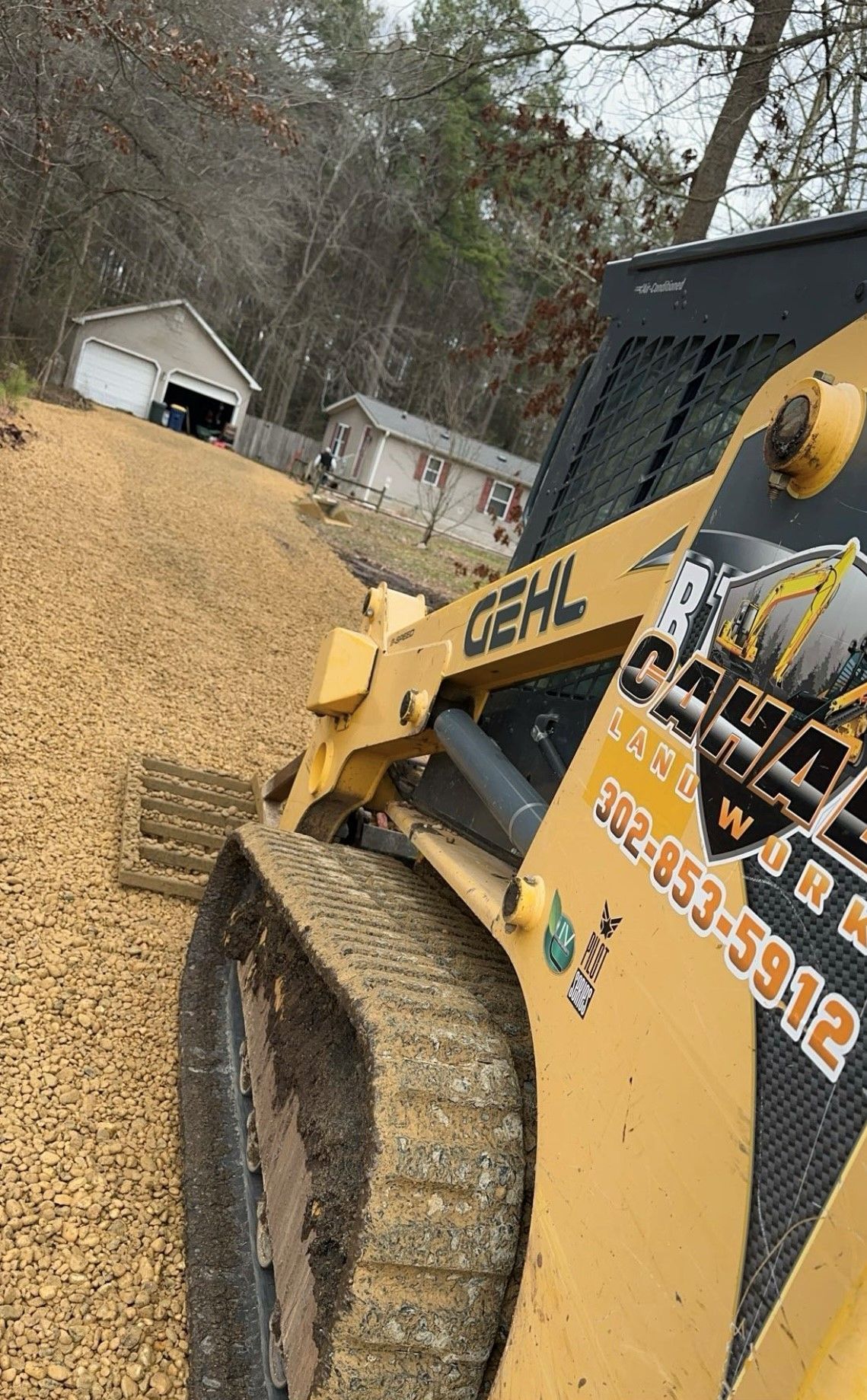A yellow tractor is sitting on top of a pile of gravel