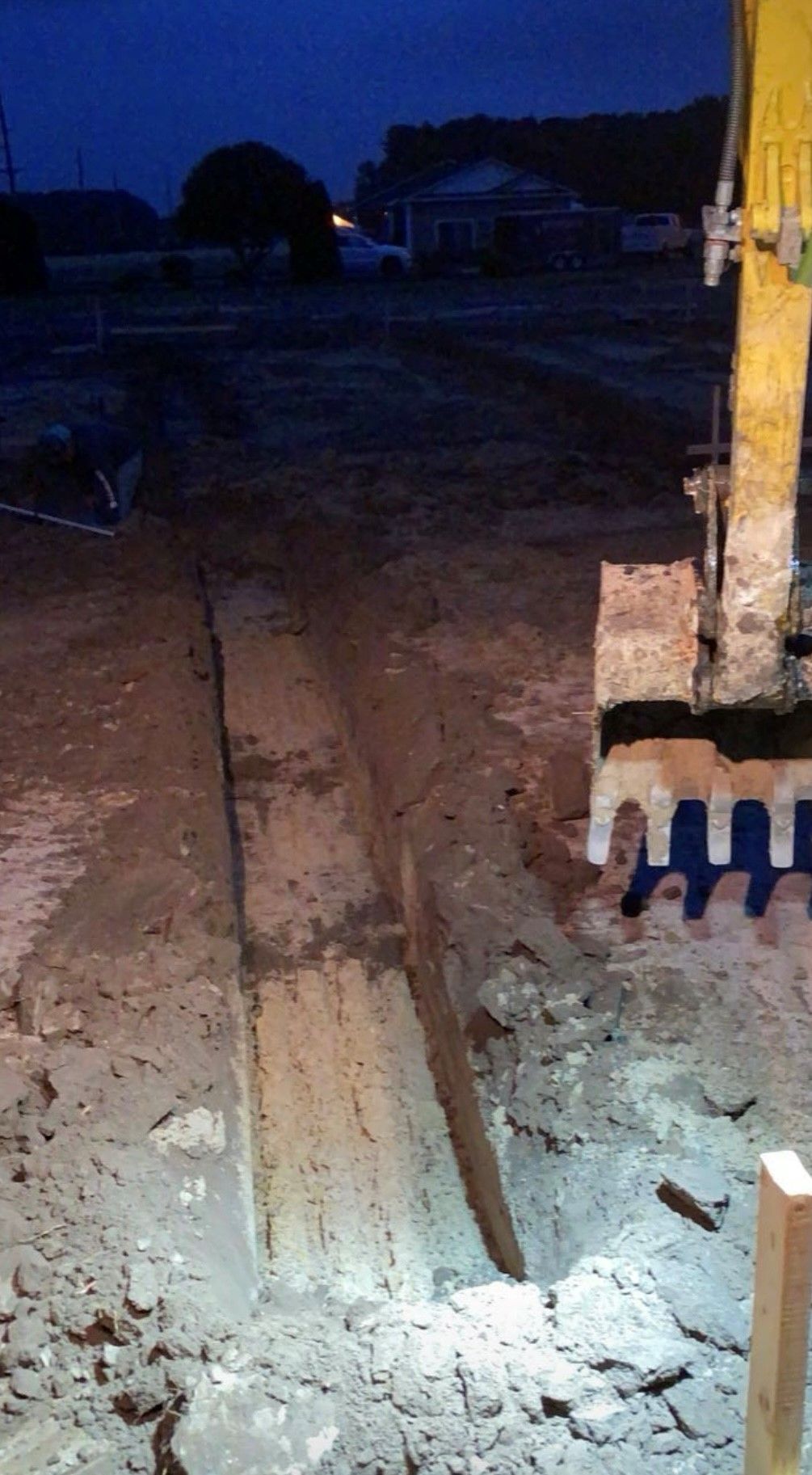 A person is digging a hole in the ground at night