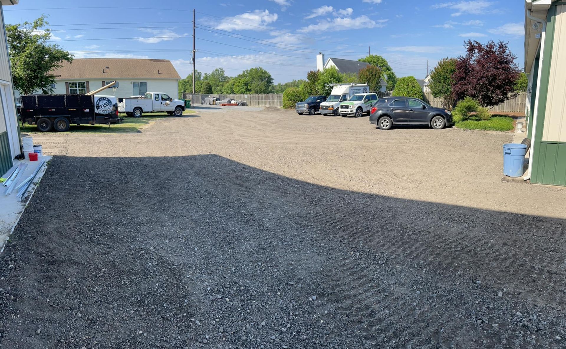 A lot of cars are parked in a driveway next to a house.