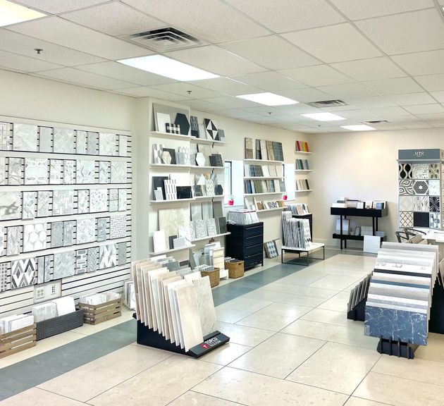 Bright showroom with shelves of bedding and textiles, white tile floor, and ceiling lights.