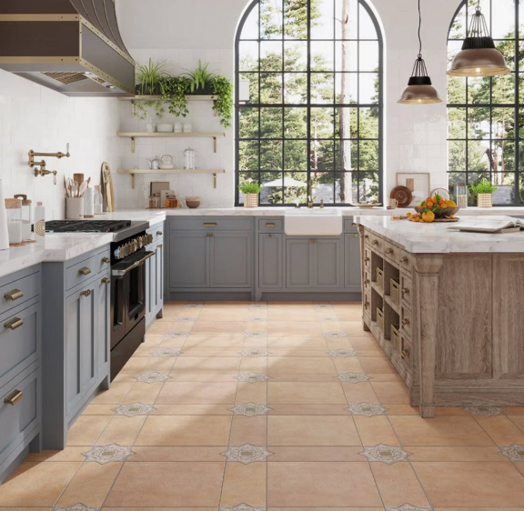 Bright kitchen with gray cabinets, large arched windows, terracotta tile floor, and a wooden island with fruit.