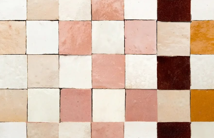 Abstract grid of hand-painted tiles in cream, pink, brown, and orange tones
