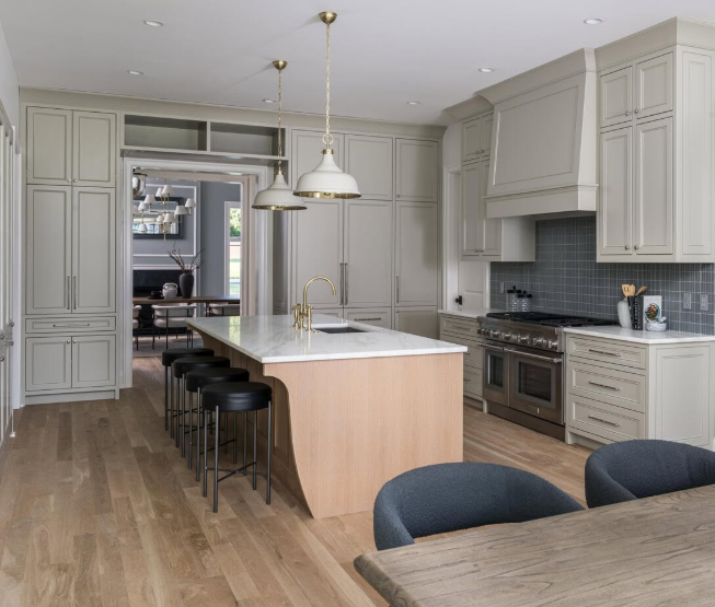 Bright modern kitchen with white cabinets, a wood island, pendant lights, and barstools.