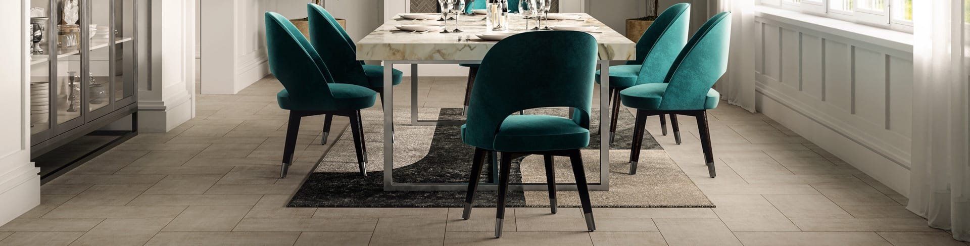 Dining room with teal chairs around a long table in a bright, modern interior.