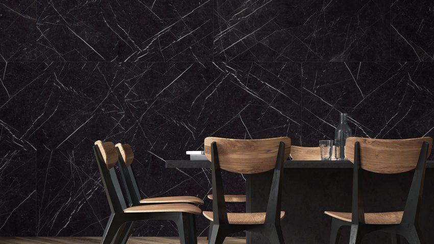 Empty café table with wooden chairs against a dark wall