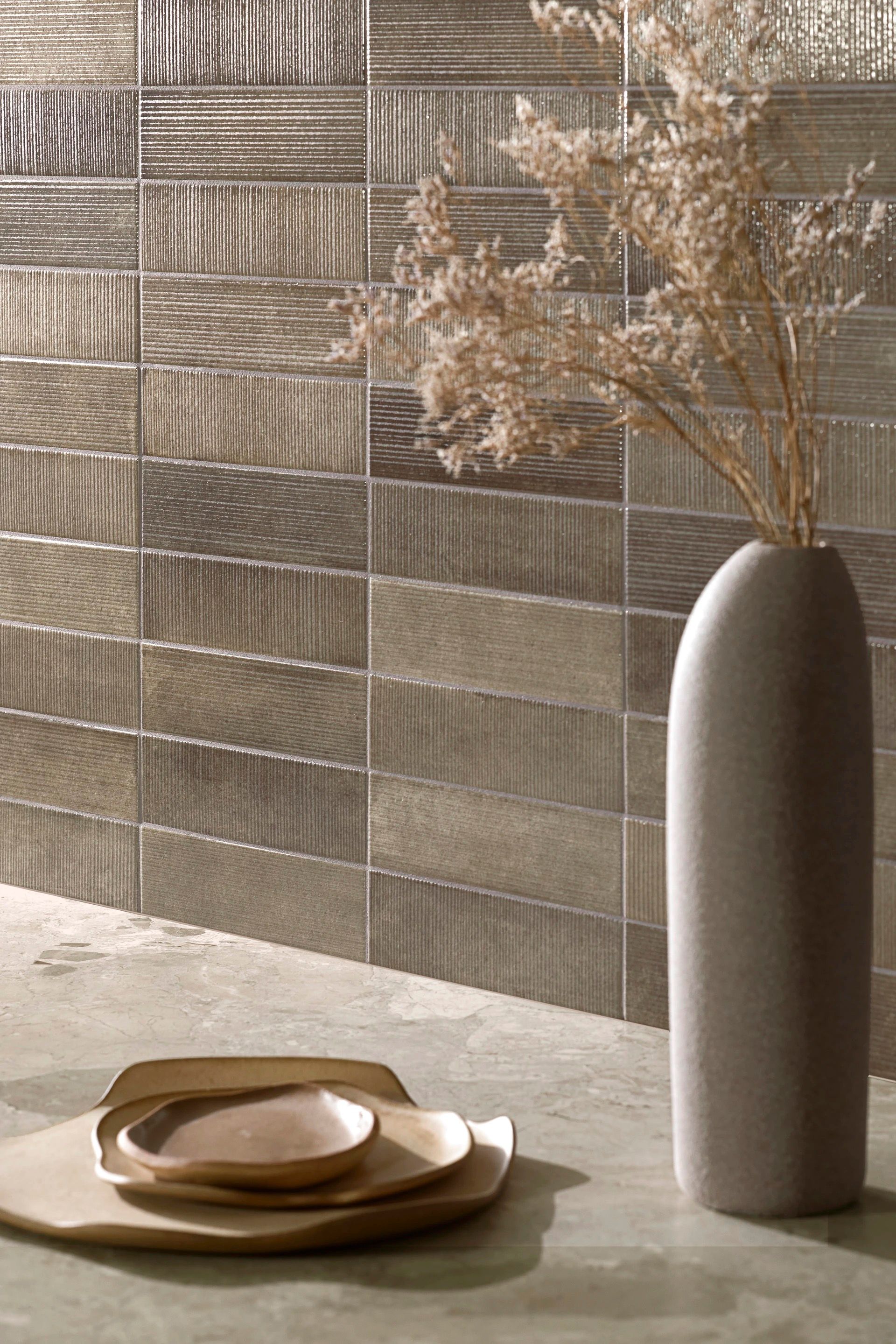 Rolled white towels on a light gray tiled bathroom floor