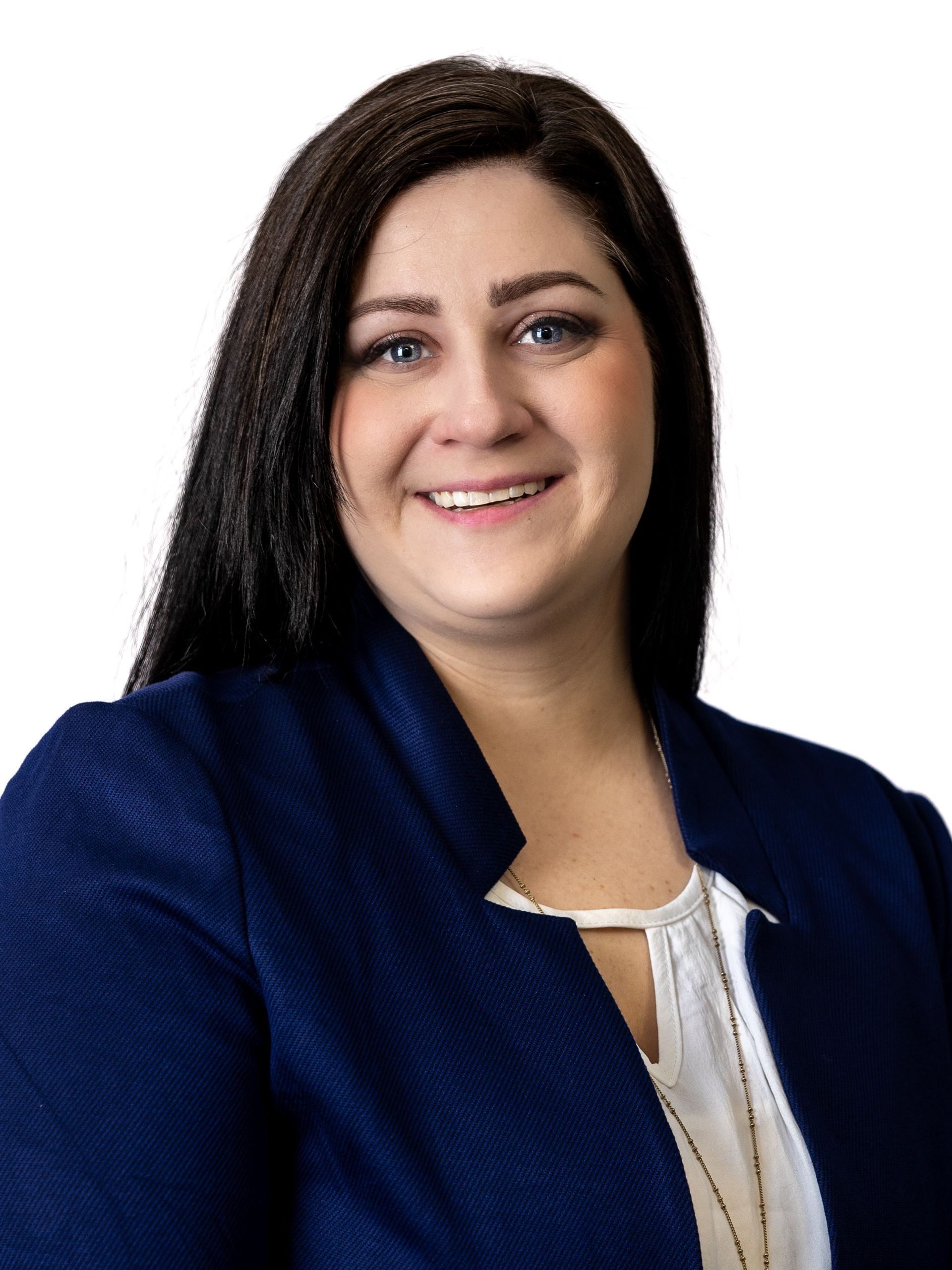 Woman smiling, wearing a blue blazer and white blouse, against a white background.