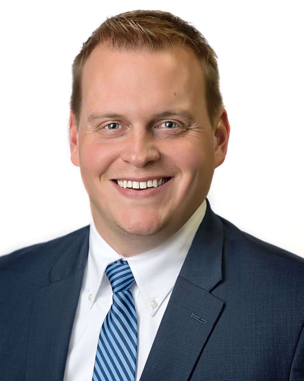 Man in suit and tie smiling at the camera. White background.