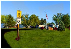 a traffic sign with a mobile homes communtity at the background