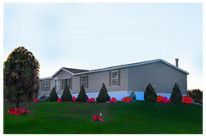 a mobile home with a beautiful front lawn garden