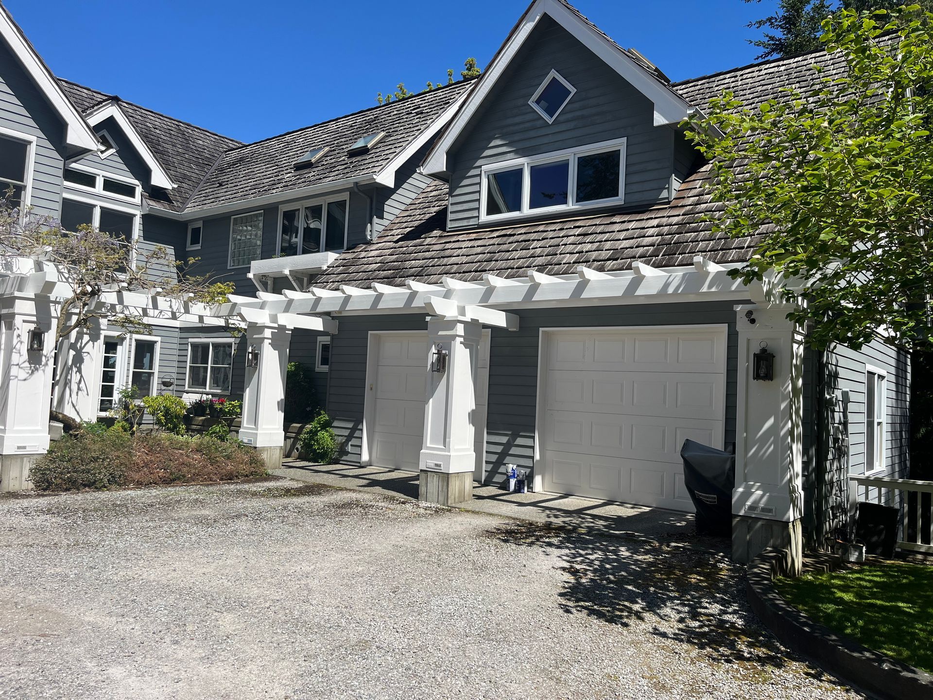 A large house with two garage doors and a pergola