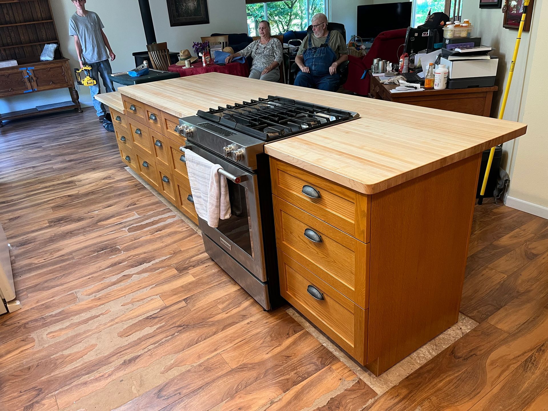 A kitchen with a large island and a stove top oven.