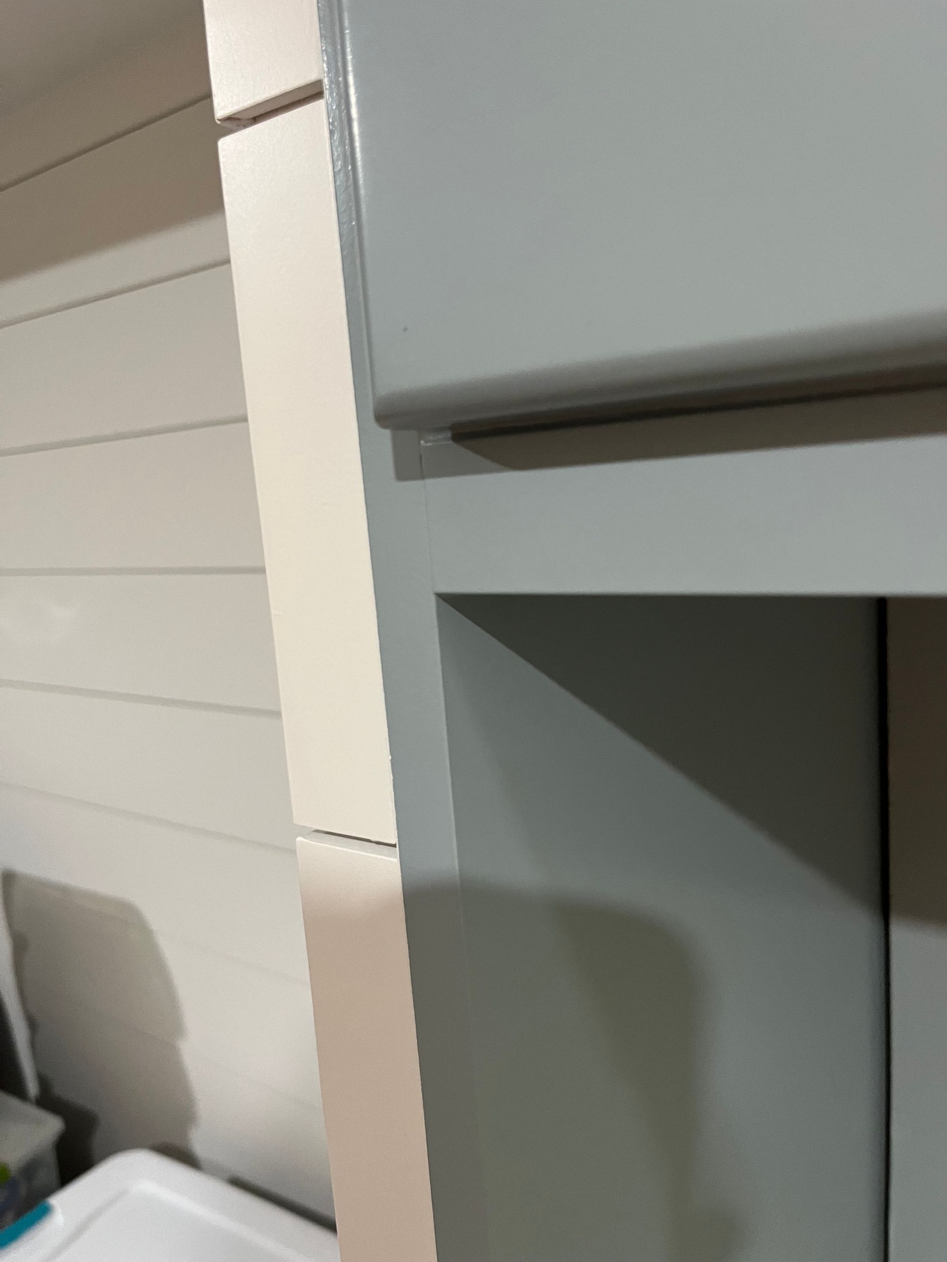 A gray cabinet in a laundry room next to a washer and dryer