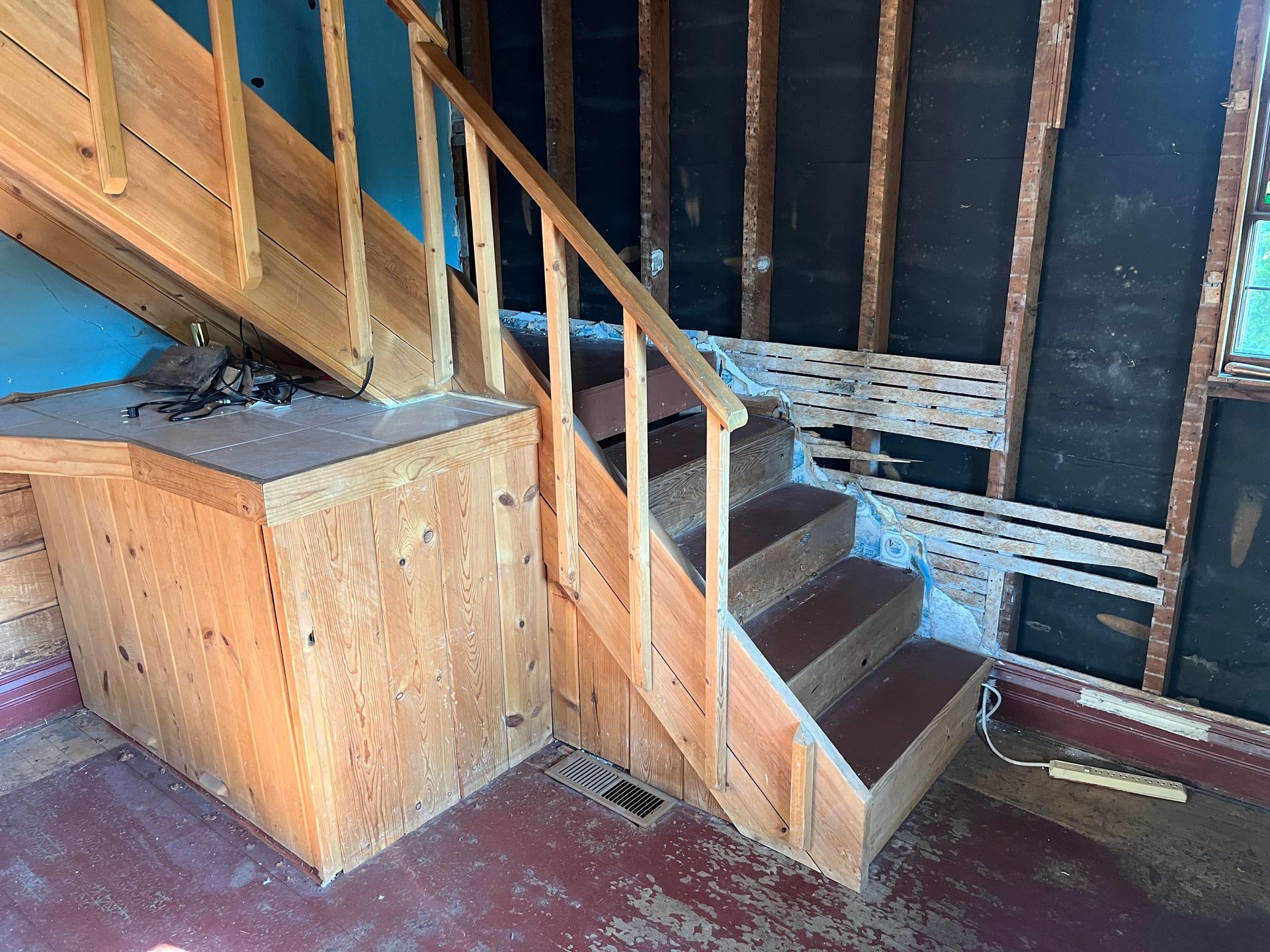 A wooden staircase is being built in a house.