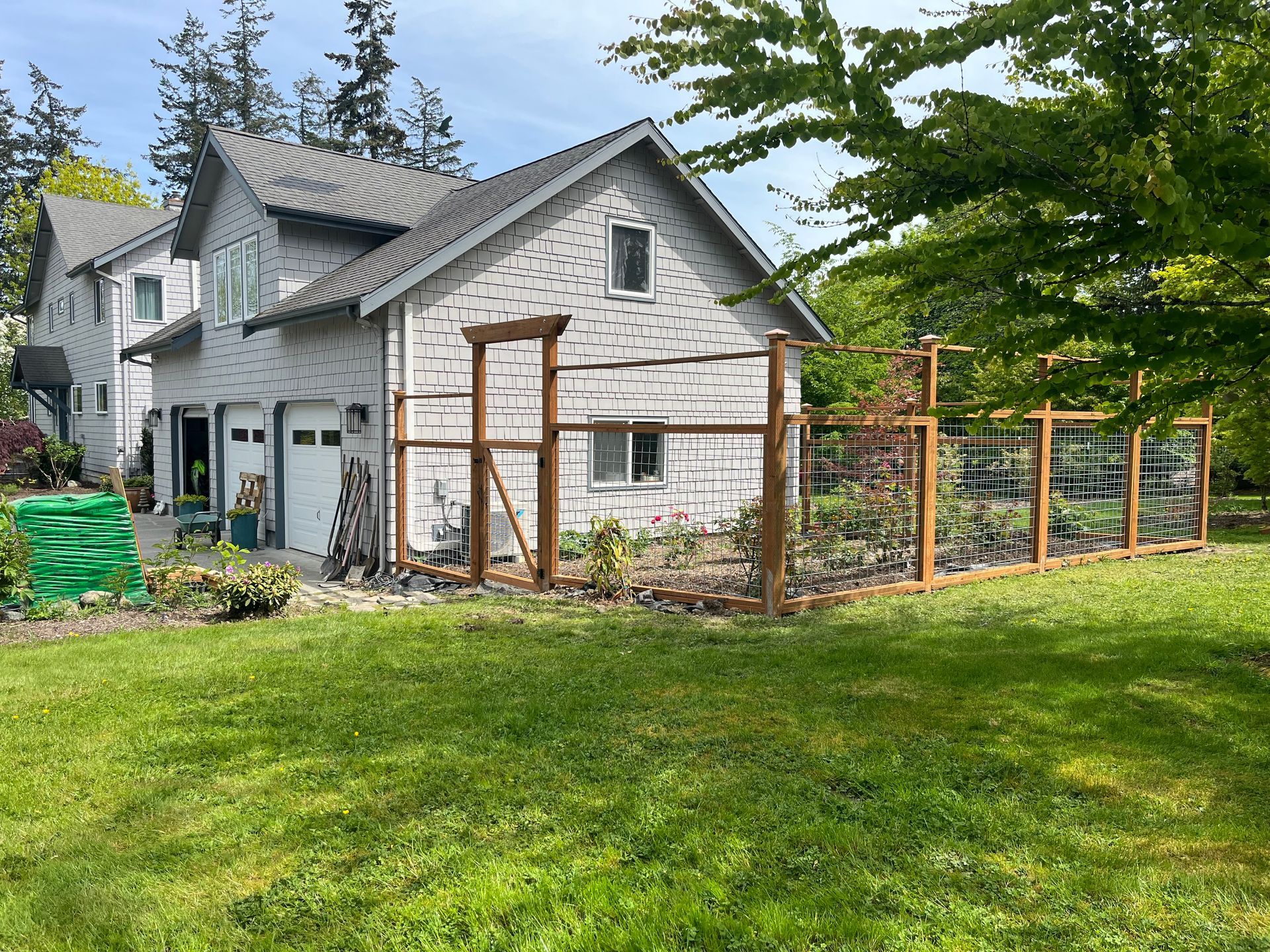 A white house with a wooden fence in front of it.