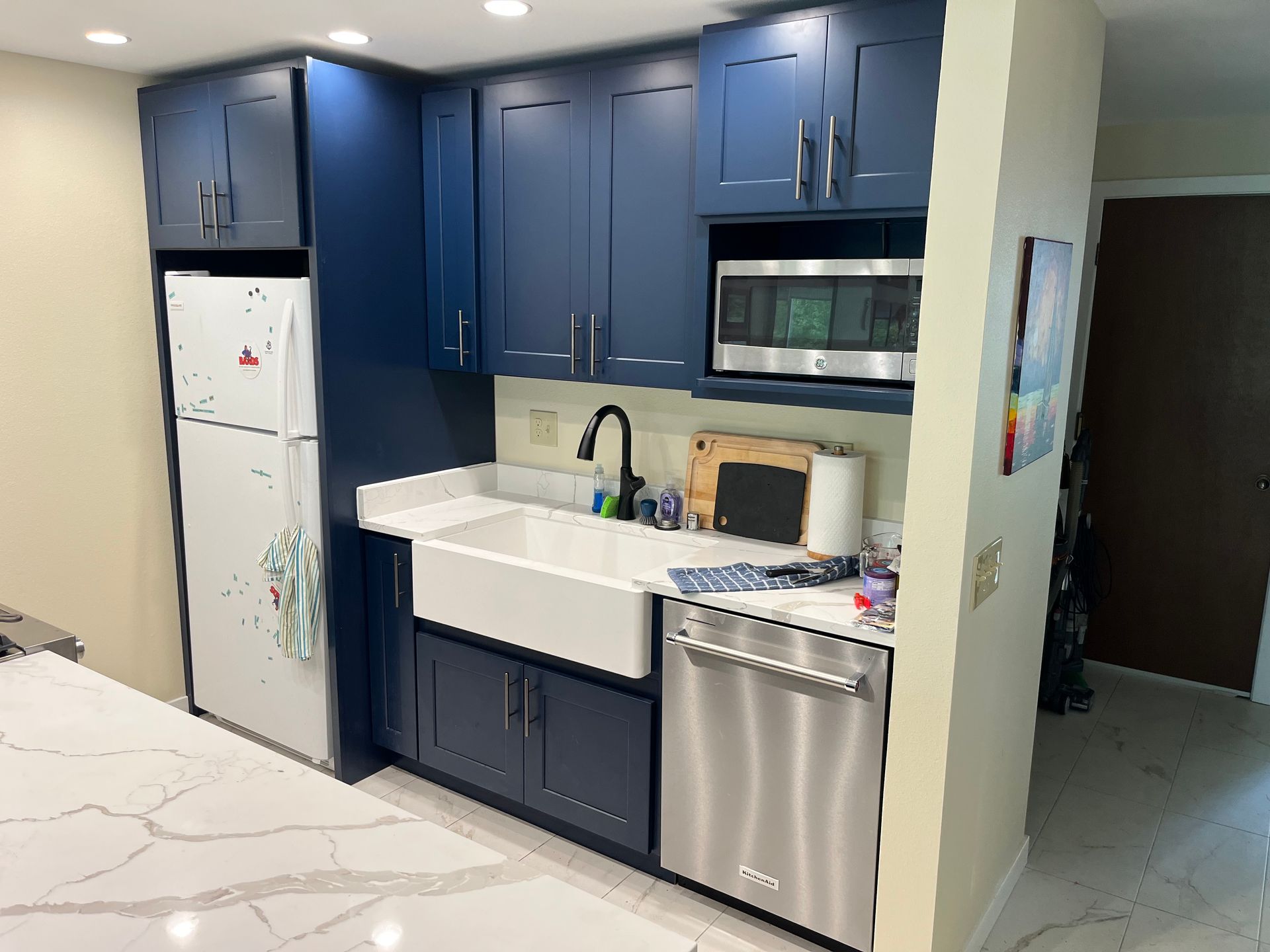 A kitchen with blue cabinets and stainless steel appliances