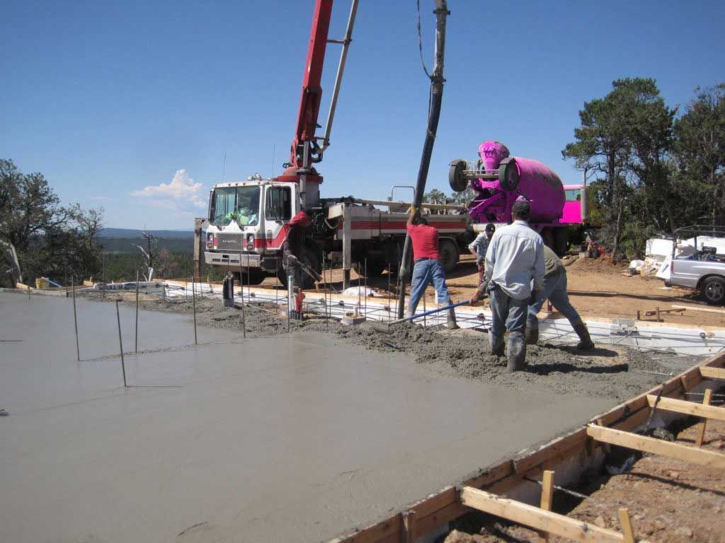 A concrete pump is being used to pour concrete on a construction site