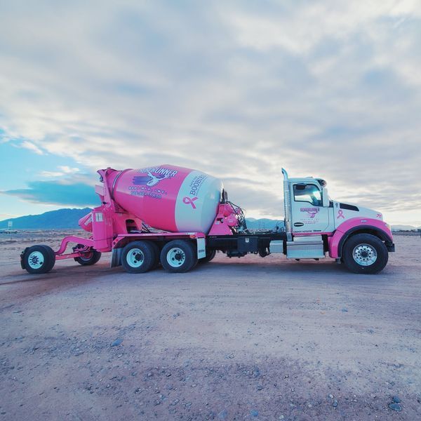A pink breast cancer truck is parked in the desert