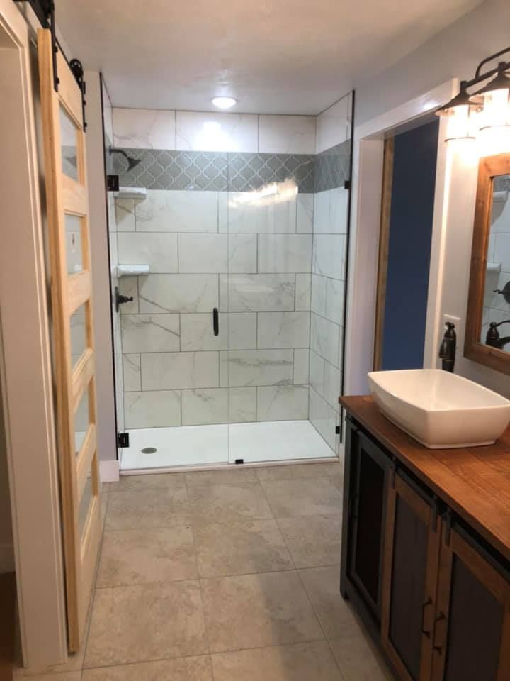 A bathroom with a sink and a walk in shower.