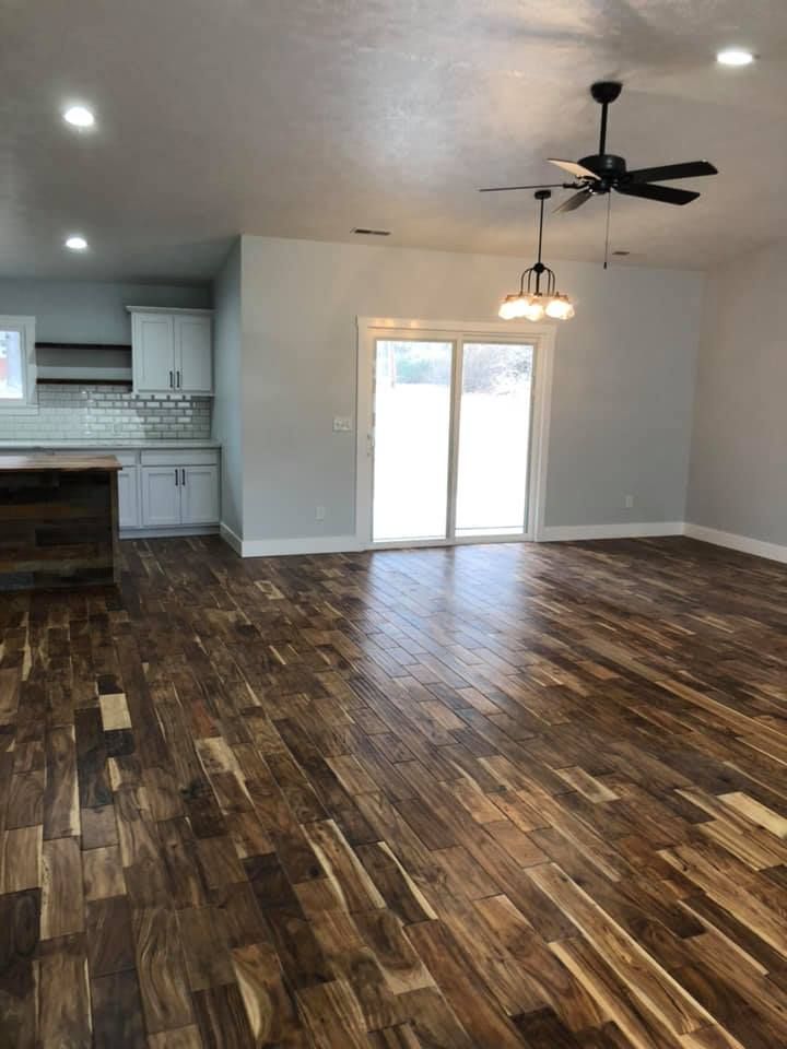 A living room with hardwood floors and a ceiling fan.