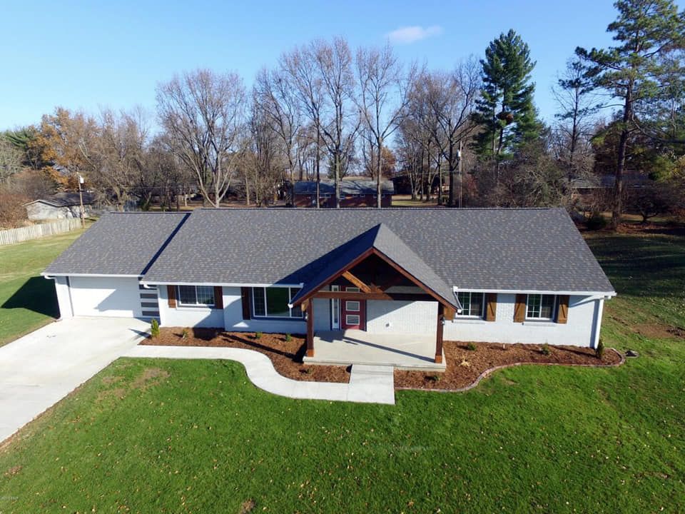 An aerial view of a house with a gray roof