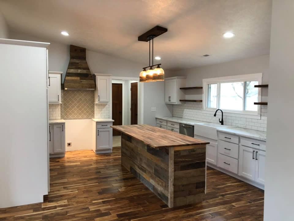 A kitchen with a large wooden island in the middle of it.