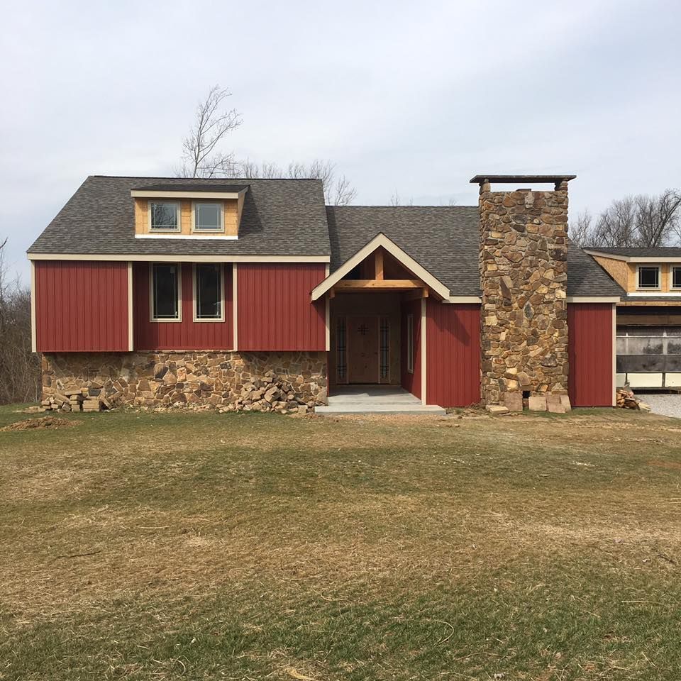 A house with red siding and a stone chimney