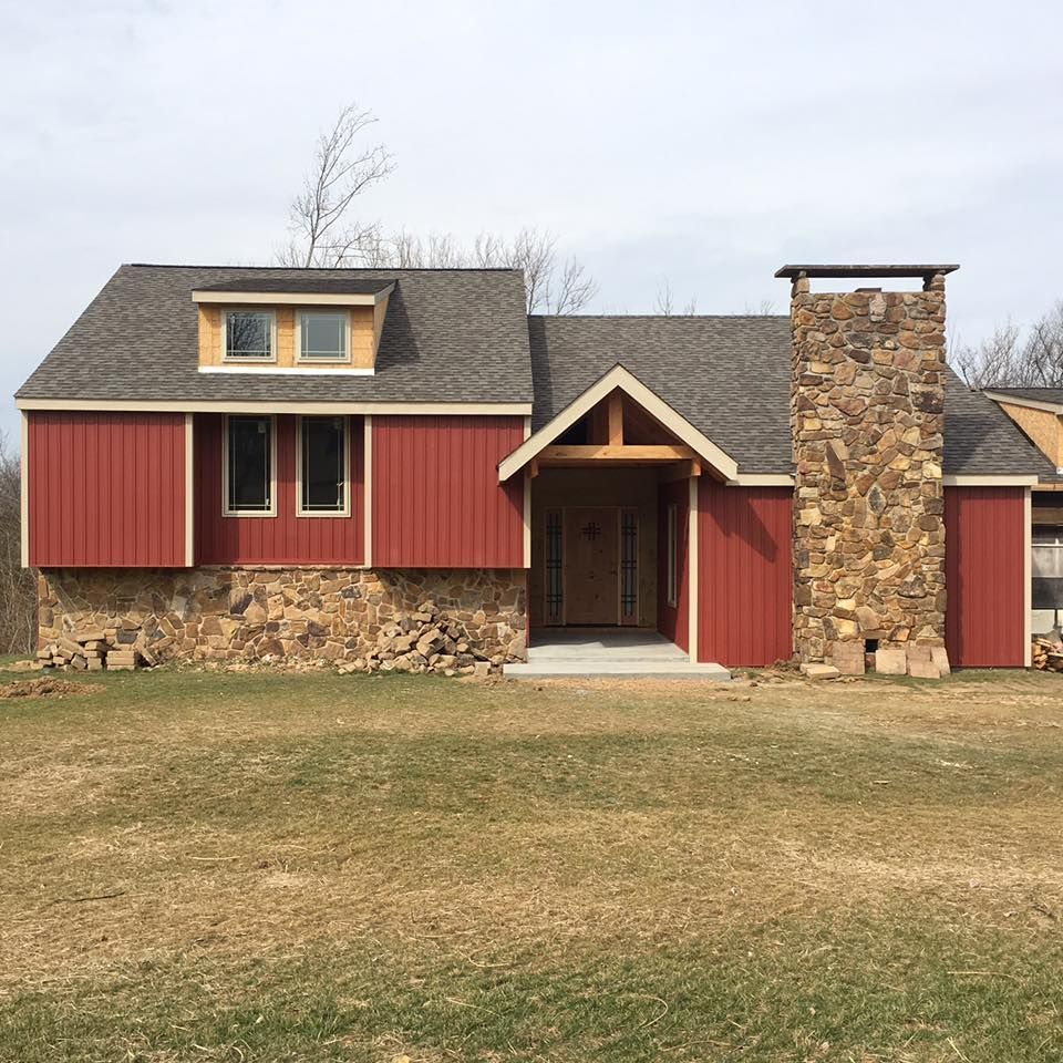 A house with red siding and a stone chimney