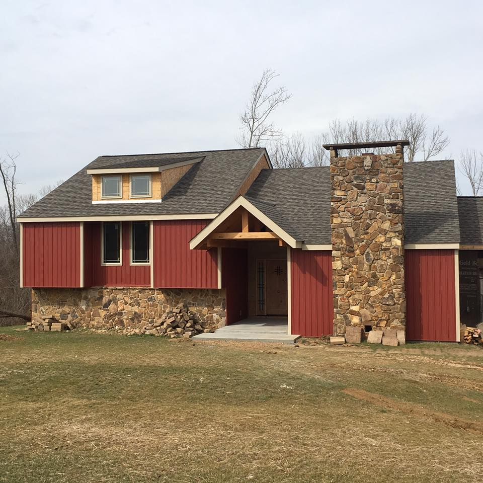 A house with red siding and a stone chimney