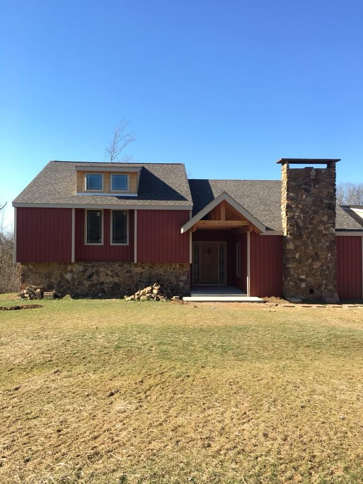 A red house with a stone chimney on the side of it