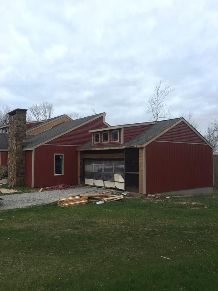 A red house with a garage and a chimney